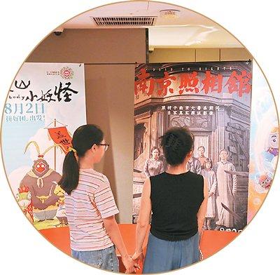 市民在浙江省嘉兴市南湖区一家影城观看电影海报。金鹏 摄(人民图片)